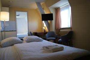 a bedroom with a bed and a desk at Fletcher Hotel Gilde in Deventer
