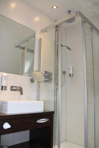 La salle de bains est pourvue d'une douche, d'un lavabo et d'un miroir. dans l'établissement Landhotel Hermannshöhe, à Legden