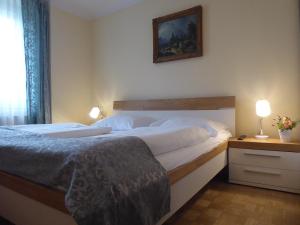 a bedroom with a bed and a night stand with a lamp at Adlerhof in Salzburg