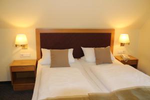ein Hotelzimmer mit 2 Betten und 2 Lampen in der Unterkunft Landhotel Hermannshöhe in Legden
