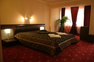 a hotel room with a bed with two towels on it at Troyan Plaza Hotel in Troyan