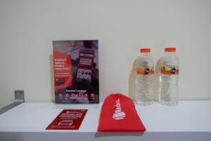 RedDoorz near Lippo Plaza Buton في Baubau: كونتر مع زجاجتين من المياه وصندوق