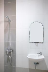a bathroom with a sink and a shower with a mirror at Gapura Residence Airport Semarang by Sinergi in Semarang