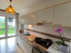 een keuken met een wastafel en een fornuis top oven bij Ferienwohnung Apartment Haus Ager in Thiersee