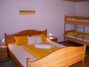 1 Schlafzimmer mit einem Holzbett und 2 Etagenbetten in der Unterkunft Ferienwohnungen Frick in Möggers