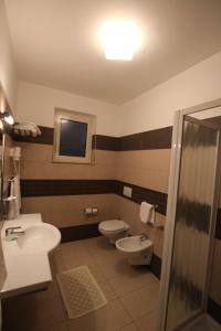 uma casa de banho com 2 WC, um lavatório e um chuveiro em Albergo Ristorante Val Vomano em Penna SantʼAndrea