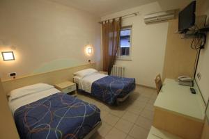 um quarto de hotel com duas camas e uma secretária em Albergo Ristorante Val Vomano em Penna SantʼAndrea