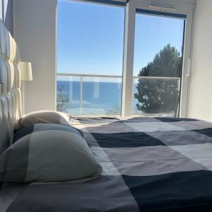 a bedroom with a bed with a view of the ocean at Amber Cliff in Mechelinki