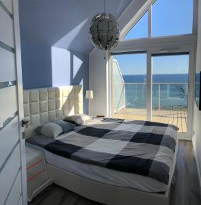 a bedroom with a bed with a view of the ocean at Amber Cliff in Mechelinki