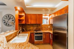 a kitchen with wooden cabinets and a stainless steel refrigerator at Molho 2BR for 6 guests in Jerusalem