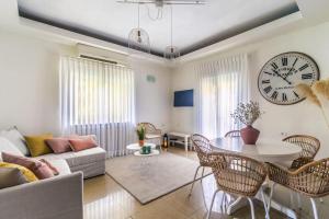 a living room with a table and a clock on the wall at Molho 2BR for 6 guests in Jerusalem