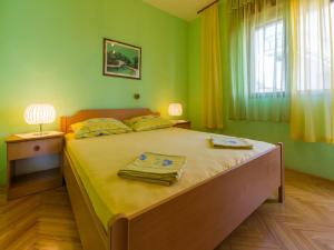 1 dormitorio con 1 cama grande y paredes verdes en Apartment MAZOR, en Crikvenica