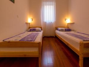 two beds in a small room with a window at Apartment Villa Sara in Dramalj