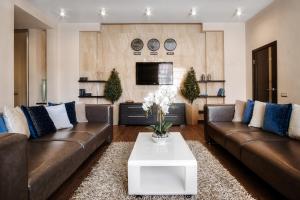 a living room with two brown couches and a coffee table at WOW EuApartments in Grodno