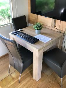 a wooden desk with a keyboard and a monitor at Evenrust, gelegen nabij het Pieterpad in Coevorden