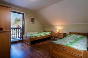 een slaapkamer met 2 bedden en een balkon bij Chalupa Josta - 4 spálne - 3 kúpeľne - krytý altánok - skibus zastávka - wifi in Jezersko