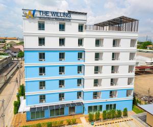 een wit en blauw gebouw met een bord erop bij The Willing Hotel and Residence in Lak Si