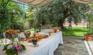 uma mesa branca com comida debaixo de um guarda-chuva em Hotel Touring em Coccaglio