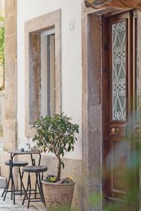 une table et des chaises avec un arbre à côté d'une porte dans l'établissement The Place Old Town Apartment, à Corfou