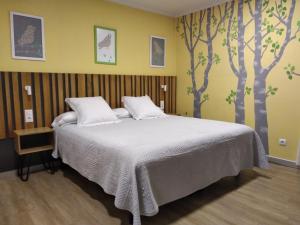 1 dormitorio con 1 cama con árboles pintados en la pared en Hostal Bríos, en Lugo