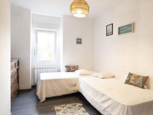 a bedroom with two beds and a window at Casa de la Abuela en el Camino de Santiago a Finiesterre in Negreira