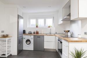 a white kitchen with a washer and dryer at Casa de la Abuela en el Camino de Santiago a Finiesterre in Negreira