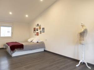 a white bedroom with a bed and a window at Casa de la Abuela en el Camino de Santiago a Finiesterre in Negreira