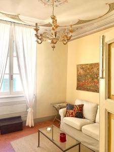 uma sala de estar com um sofá e um lustre em Stefania Townhouse em Montepulciano