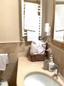 bagno con lavandino, specchio e asciugamani di Stefania Townhouse a Montepulciano