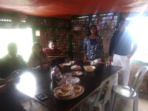 a group of people sitting around a table at Tragopan Homestay in Aritar