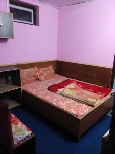 Un dormitorio con una cama con una manta roja. en Vamoose Tragopan, en Aritar