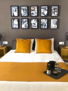 Schlafzimmer mit einem Bett mit gelben Kissen und Bildern an der Wand in der Unterkunft Apartamentos Élite - Art Collection - Pablo in Merida