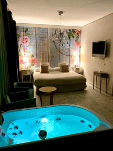 a room with a bed and a tub in a room at Hotel Spa Adealba in Mérida