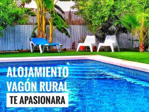 a swimming pool with chairs and a sign that reads albuquerque zacionruza at OasisTrain 03 - Alojamiento Vagón Rural in Murcia
