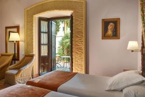 1 dormitorio con 1 cama y puerta que da a un patio en Parador de Ubeda, en Úbeda