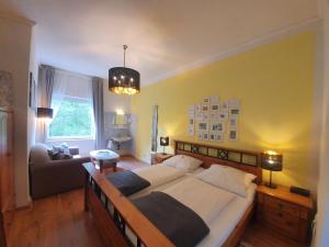 um quarto com uma cama grande e um sofá em Pension Seeschlösschen em Mölln