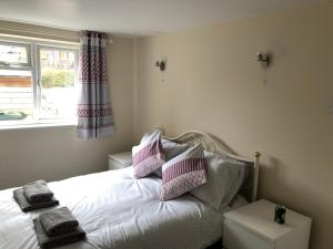 1 dormitorio con 1 cama con almohadas rosas y blancas en 9 Bromleys Court en Church Stretton