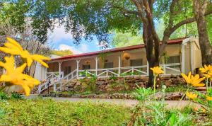 uma casa com flores amarelas em frente em Travel Hotel Eilon em Elon