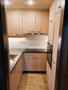 a kitchen with wooden cabinets and black counter tops at Le gîte Martin in Dinant