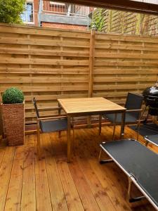 une table et des chaises en bois sur une terrasse en bois dans l'établissement Ferienwohnung Altstadt Perle_ 15164, à Leer