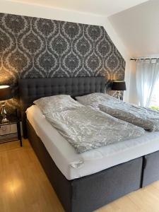- une chambre avec un grand lit et une tête de lit dans l'établissement Ferienwohnung Altstadt Perle_ 15164, à Leer