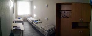 a room with three beds and a window at Penates Hostel in Yekaterinburg