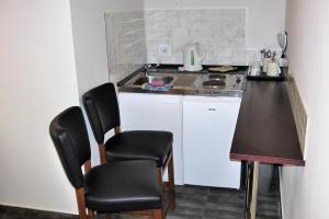a kitchen with a table and chairs in it at Green Lake Park Apartments in Vecsés