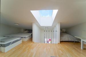 Schlafzimmer im Dachgeschoss mit 2 Betten und einem Dachfenster in der Unterkunft Three-Bedroom Apartment in Tjørhom