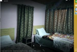 um quarto com duas camas num quarto com cortinas em Hunza Huts Duikar Altit em Baltit