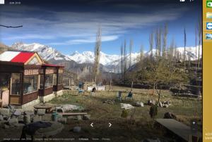 a building with a view of snow covered mountains at Hunza Huts Duikar Altit in Baltit