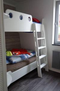 a white bunk bed with a ladder in a room at Schönes Ferienhaus in Maasholm Bad, Ostsee in Maasholm