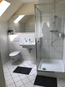 ein Bad mit einer Dusche, einem Waschbecken und einem WC in der Unterkunft Hotel Rahserhof in Viersen