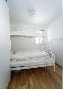 a white bunk bed in a room with a mirror at Three-Bedroom Apartment in Tjørhom