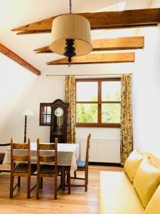 a dining room with a table and chairs and a couch at Domjana Lubiatowo in Lubiatowo